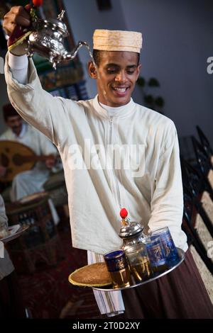 Cameriere che versa il tè al Marhaba Palace, un lussuoso ristorante del palazzo nella città vecchia. Tangeri. Marocco Foto Stock