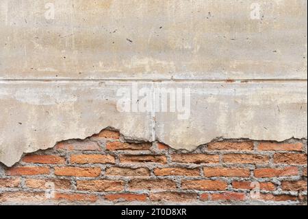 Consistenza di un vecchio muro di mattoni con intonaco caduto Foto Stock