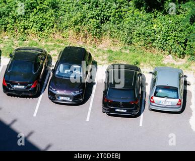 Strasburgo, Francia - 5 giugno 2023: Una varietà di auto - Renault, VW, SUV, station wagon, Citroen, e modelli DS - in piedi parcheggiati di fila, sullo sfondo di boccole torreggianti Foto Stock