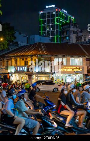 Sciami di motociclette in una strada trafficata di notte a ho chi Minh City, Vietnam Foto Stock