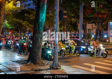 Sciami di motociclette in una strada trafficata di notte a ho chi Minh City, Vietnam Foto Stock