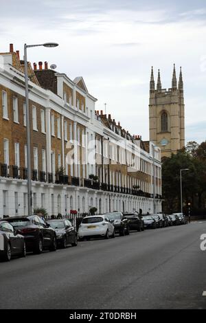 Alloggi terrazzati sulla Sydney Street St Luke's Church Bell Tower dietro Chelsea Londra Inghilterra Foto Stock