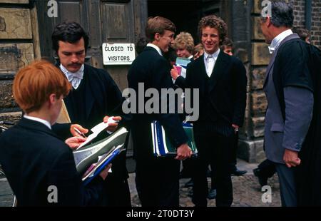 Studenti dell'Eton College che indossano l'uniforme tradizionale con libri al di fuori del College Berkshire Inghilterra Foto Stock