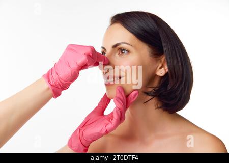 Ritratto della giovane e bella donna sorridente che si prepara per le procedure di chirurgia plastica dal medico toccando il viso, il naso, il mento. Foto Stock