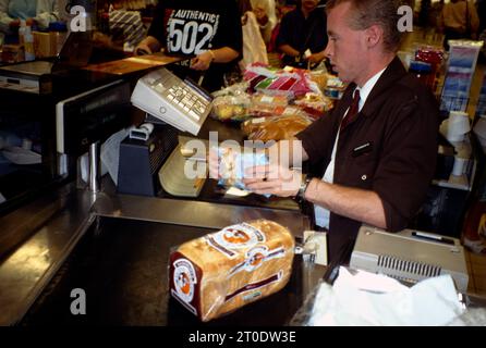 Young Assistant che esegue la scansione di codici a barre in un supermercato in Inghilterra Foto Stock