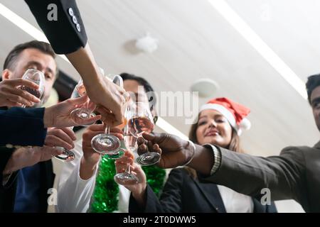 Fare un brindisi, Cheers!! Un gruppo di persone e colleghi che si divertono e si incontrano a una festa di Capodanno. Un lavoro di squadra c Foto Stock