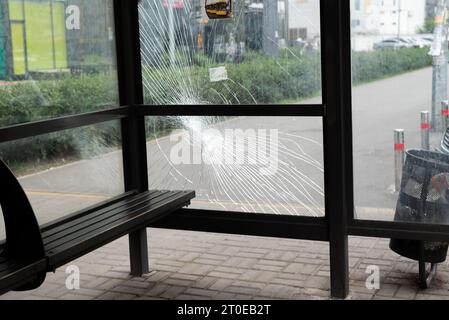 Vetri rotti alla fermata dell'autobus. Stazione dei trasporti pubblici vandalizzata dalle finestre di vetro. incrinature del vetro temperato Foto Stock