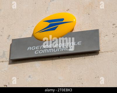 Insegna dell'agenzia postale francese con logo giallo e blu sul muro dell'edificio Foto Stock