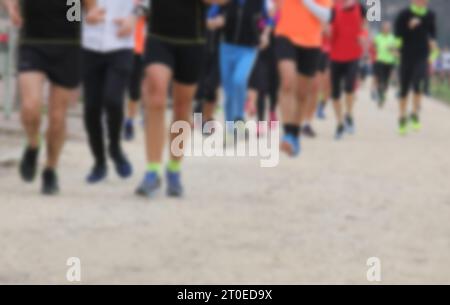 gambe intenzionalmente fuori fuoco dei corridori che corrono in gruppo durante la corsa a piedi in città Foto Stock
