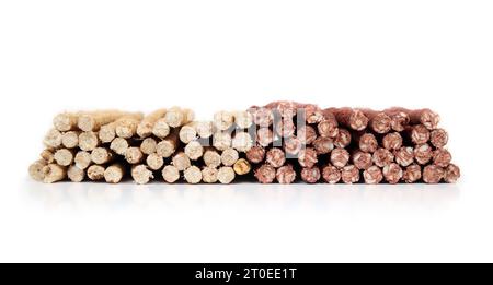 Molti bastoncini da masticare per cani, vista frontale. Grande quantità di bastoncini aromatizzati al pollo e al manzo impilati. Trattamenti di salute dentale per cani e comportamentale Foto Stock