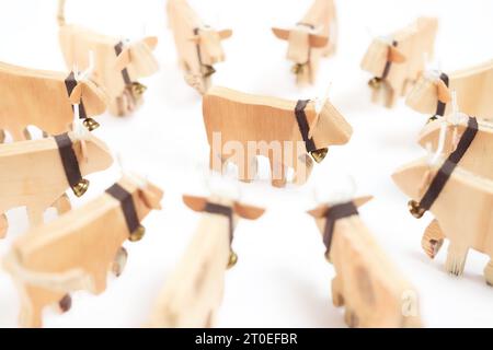 Mucca in un gruppo di mucche che formano un cerchio. Concetto per vincere, leadership, distinguersi o isolarsi. Silhouette di mucca in legno lavorate a mano con campane. SEL Foto Stock