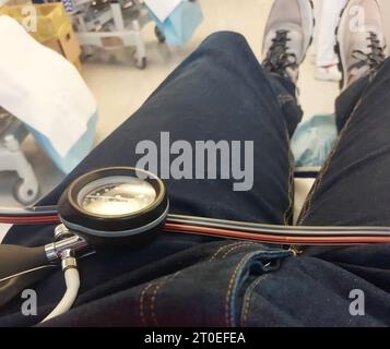 paziente giovane sdraiato sul letto d'ospedale con manometro per la misurazione della pressione sanguigna dopo la caduta di zucchero nel sangue Foto Stock