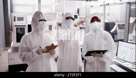 Fabbrica di produzione di semiconduttori sterile e lavoratori in tute Foto Stock