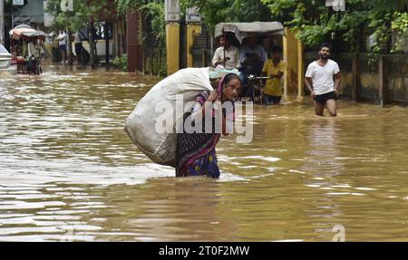 Guwahati, Guwahati, India. 6 ottobre 2023. Venerdì 6 ottobre 2023, una donna cammina attraverso l'area allagata dopo le forti piogge a Guwahati Assam in India. (Immagine di credito: © Dasarath Deka/ZUMA Press Wire) SOLO USO EDITORIALE! Non per USO commerciale! Foto Stock