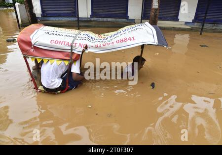 Guwahati, Guwahati, India. 6 ottobre 2023. Venerdì 6 ottobre 2023, un estrattore di risciò attraversa la strada allagata dopo una forte pioggia a Guwahati Assam in India. (Immagine di credito: © Dasarath Deka/ZUMA Press Wire) SOLO USO EDITORIALE! Non per USO commerciale! Foto Stock