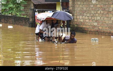 Guwahati, Guwahati, India. 6 ottobre 2023. Venerdì 6 ottobre 2023, un estrattore di risciò attraversa la strada allagata dopo una forte pioggia a Guwahati Assam in India. (Immagine di credito: © Dasarath Deka/ZUMA Press Wire) SOLO USO EDITORIALE! Non per USO commerciale! Foto Stock