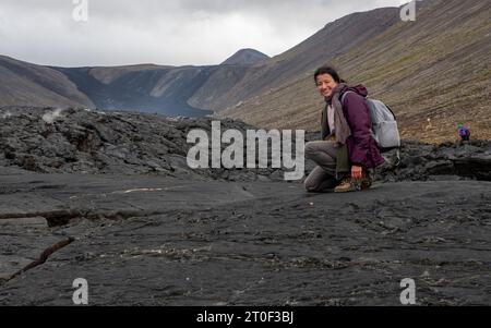 Una donna sul Fagradalsfjall del 2022, ventilazione di eruzione vulcanica vicino a Reykjavik in Islanda Foto Stock