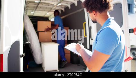 I traslocatori che controllano le caselle di consegna e compilano il documento Foto Stock