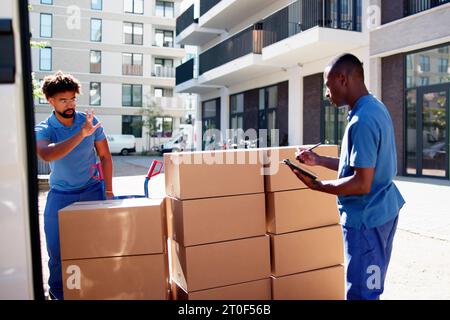 I traslocatori che controllano le caselle di consegna e compilano il documento Foto Stock