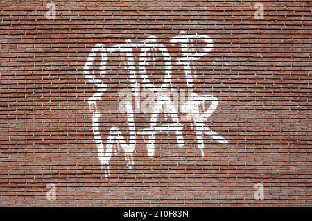 Phrase Stop War spray dipinto di bianco su un muro di mattoni Foto Stock