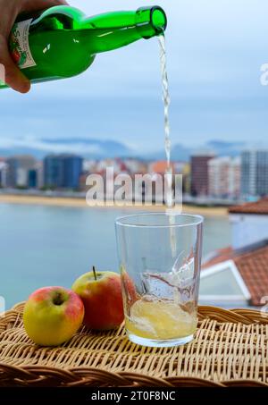 Il sidro asturiano naturale tradizionale fatto da mele fermentate in barile di legno dovrebbe essere versato dalla grande altezza per le bolle d'aria nella bevanda e v Foto Stock