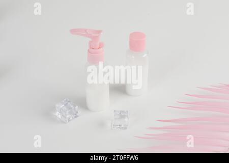 Bottiglia di vetro per cosmetici di bellezza. modello di branding, vista frontale su sfondo rosa pastello e bianco. Pacchetto per olio essenziale. Foto Stock