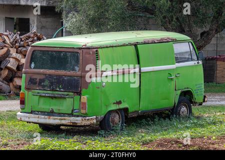 un camper volkswagen che si arrugginisce in un giardino in grecia. camper volkswagen vintage abbandonato. Foto Stock