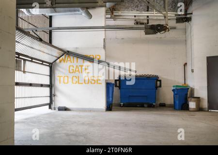 Cancello di parcheggio danneggiato nel parcheggio dell'edificio. Uscita dal garage dell'edificio a strati con sportello a sezione sospesa rotto. Pista tagliata dal muro. Professionale Foto Stock