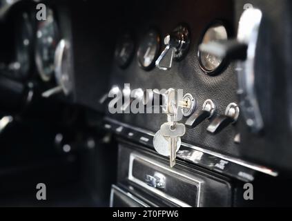 Cruscotto o cockpit per auto d'epoca con chiave di accensione inserita. Auto classica o sportiva. Strumenti e interruttori di muscle car o coupé ad alte prestazioni. Automatico Foto Stock