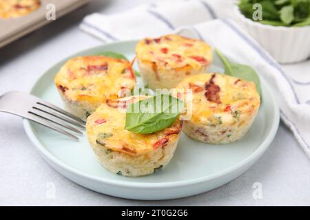 Pancetta appena sfornata e muffin all'uovo con formaggio servito al tavolo, primo piano Foto Stock