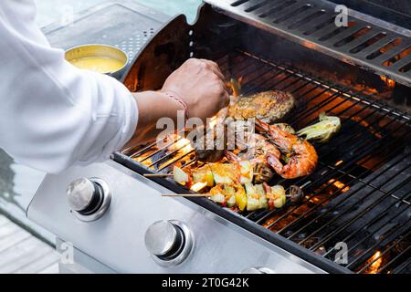 Verdure grigliate e spiedini di carne in una marinata di erbe in una padella per grigliare, vista dall'alto Foto Stock