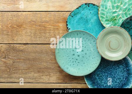 Set di piastre in ceramica turchese su tavolo in legno Foto Stock