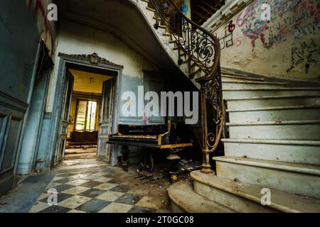 corridoio vuoto con un vecchio pianoforte rotto in una villa abbandonata Foto Stock