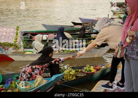 Banjarmasin, Indonesia, 24 settembre 2023: Commercianti galleggianti sulle barche, vendono a Siring, Banjarmasin City, domenica mattina Foto Stock