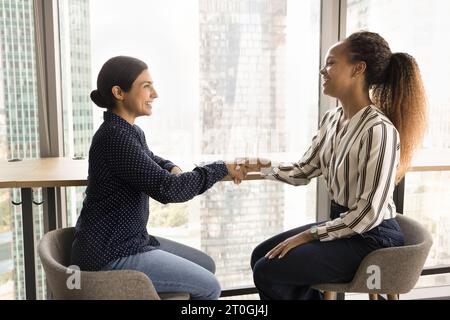 Diverse giovani partner d'affari donne che stringono la mano Foto Stock