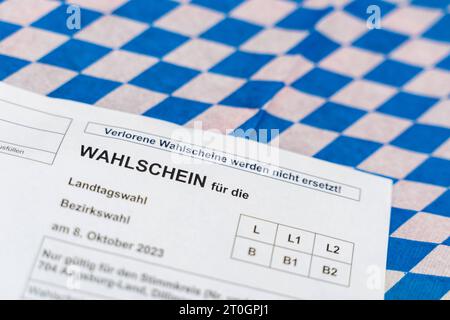 Augusta, Baviera, Germania - 29 settembre 2023: Scheda elettorale per le elezioni statali e distrettuali in Baviera su bandiera bavarese *** Wahlschein zur Landtagswahl und Bezirkswahl in Bayern auf einer bayerischen Flagge Foto Stock