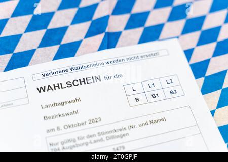 Augusta, Baviera, Germania - 29 settembre 2023: Scheda elettorale per le elezioni statali e distrettuali in Baviera su bandiera bavarese *** Wahlschein zur Landtagswahl und Bezirkswahl in Bayern auf einer bayerischen Flagge Foto Stock