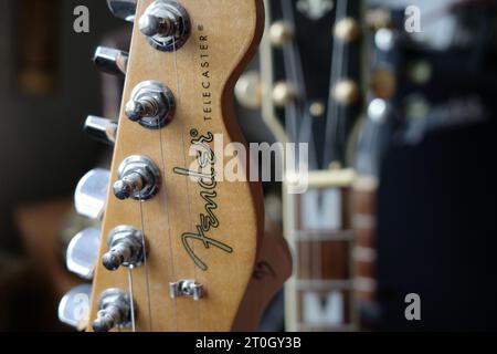 Itterbeck, Germania - 6 ottobre 2023 primo piano di una chitarra testa di Fender Telecaster. Sfocate sullo sfondo le altre chitarre Foto Stock