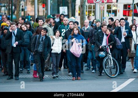 Pendolari diretti a casa all'attraversamento pedonale fuori dalla stazione di Flinders Street a Melbourne, Australia Foto Stock