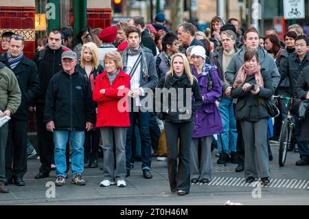 Pendolari diretti a casa all'attraversamento pedonale fuori dalla stazione di Flinders Street a Melbourne, Australia Foto Stock