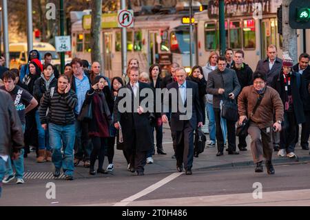 Pendolari diretti a casa all'attraversamento pedonale fuori dalla stazione di Flinders Street a Melbourne, Australia Foto Stock