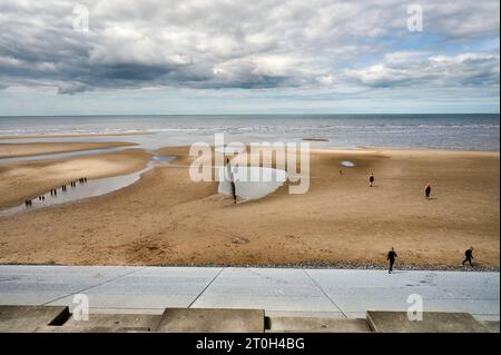 Spiaggia con vecchi groynes di legname rotto e nuova diga Foto Stock