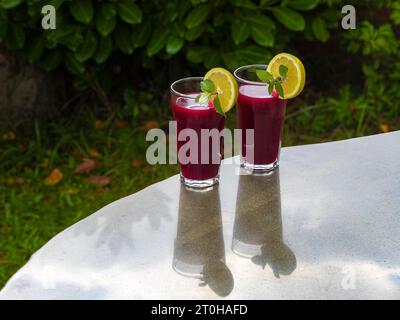 Spremuta fresca di barbabietola con mela e limone in un bicchiere da succo Foto Stock