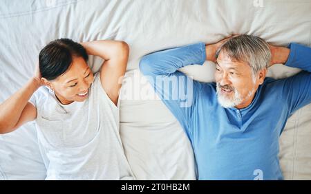 Letto, viso e coppia asiatica matura che dorme, stanco o pisolino per la cura del partner, il benessere mattutino o il riposo in pensione. Vista dall'alto, sorriso e donna anziana, uomo o. Foto Stock