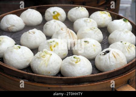 Messa a fuoco selettiva ai primi gnocchi gnocchi asiatici, chiamati dim sum, che cucinano in una vaporiera di legno a Shanghai, in Cina Foto Stock