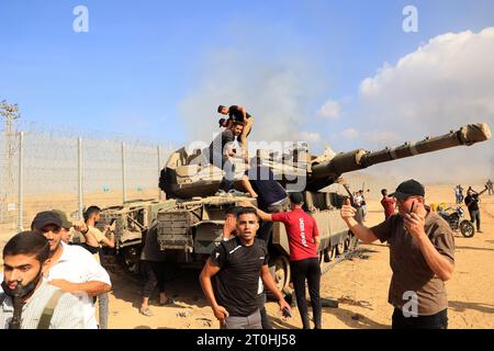 Rafah, Gaza. 7 ottobre 2023. I palestinesi prendono il controllo di un carro armato israeliano dopo aver attraversato la recinzione di confine con Israele da Khan Yunis nella Striscia di Gaza meridionale sabato 7 ottobre 2023. All'alba, dalla Striscia di Gaza sono stati lanciati attacchi di razzi contro Israele mentre i militanti dell'enclave palestinese bloccata si infiltravano in Israele. Foto di Ismael Mohamad/UPI. Crediti: UPI/Alamy Live News Foto Stock