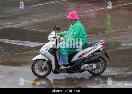 SAMUT PRAKAN, THAILANDIA, 20 settembre 2023, Un motociclista con un impermeabile guida una motocicletta sotto la pioggia Foto Stock