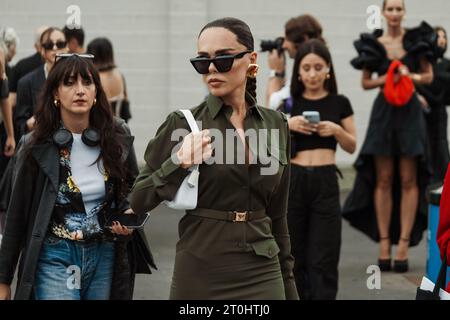 Evangelie Smyrniotaki indossa occhiali da sole neri, orecchini dorati, abito abbottonato verde visto all'esterno della sfilata PRADA durante la settimana della moda milanese Spri Foto Stock