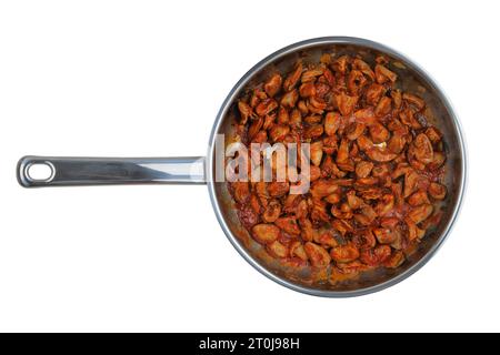 I cuori di pollo con prezzemolo e pomodori vengono fritti in una padella di metallo isolata su fondo bianco. Cucina casalinga o culinaria. Piatto fatto in casa. Foto Stock