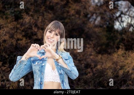 Scena da sogno: Persona che crea una forma di cuore in mezzo alla natura Foto Stock